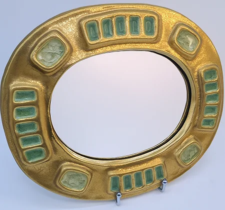 Mithé Espelt (1923-2020). Miroir mural ovale à encadrement en céramique émaillée dorée et craquelée, agrémentée de cabochons en verre coloré. L.29,5 x H.25 cm. Pastor Maison de ventes - Le 06/04/2025 - lot 90 - Estimations : 400 € - 500 € - Adjugé à 2010 €