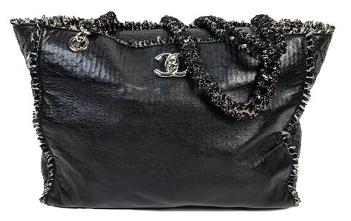 Chanel. Sac Shopping En Agneau Noir, Intérieur En Tweed Pied-de-poule Noir Et Blanc, Deux Anses Chaines Entrelacées De Tweed Métallisé, Bijouterie En Métal Palladié, Présence De L'étiquette d'authenticité. Très Bon état, Pochon d'origine, Circa 2009. (h: 26 X L: 35 X P: 10 Cm) Expertise Jérôme Lalande. Estimations : 700€ à 900 € - Pièce Adjugée 1630 €