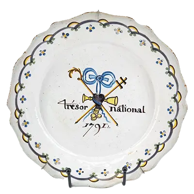 Assiette patriotique en faïence et décor polychrome. NEVERS. Assiette à bord chantourné en faïence, décor polychrome révolutionnaire au "Trésor national", daté 1791.