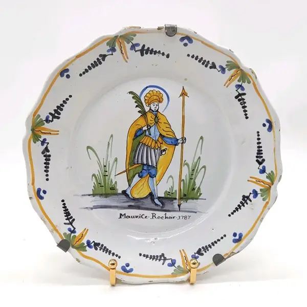 NEVERS, XVIIIe siècle . Assiette patronymique en faïence polychrome représentant Saint-Maurice . Inscription et date "Maurice Rochoir 1787" en dessous