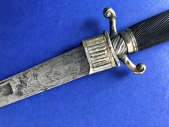 Couteau de chasse, garnitures argent, poignet en ébène, lame gravée de motifs cynégétiques. XVIIIème